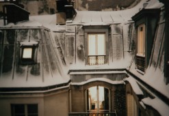 Photo de toits enneigés à Paris la nuit